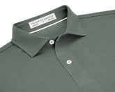 The Neville Shirt: Ivy, featuring a green polo design with a collar, two white buttons, and a label indicating HOLDERNESS & BOURNE, Tailored Fit, M, Made in Peru.