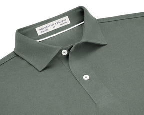 The Neville Shirt: Ivy, featuring a green polo design with a collar, two white buttons, and a label indicating HOLDERNESS & BOURNE, Tailored Fit, M, Made in Peru.