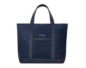The Treadwell Tote: Navy Ballistic - Slate Blue Embroidery, featuring dual handles, leather trim, front slip pocket, and personalized initials CMB. Ideal for versatile use.