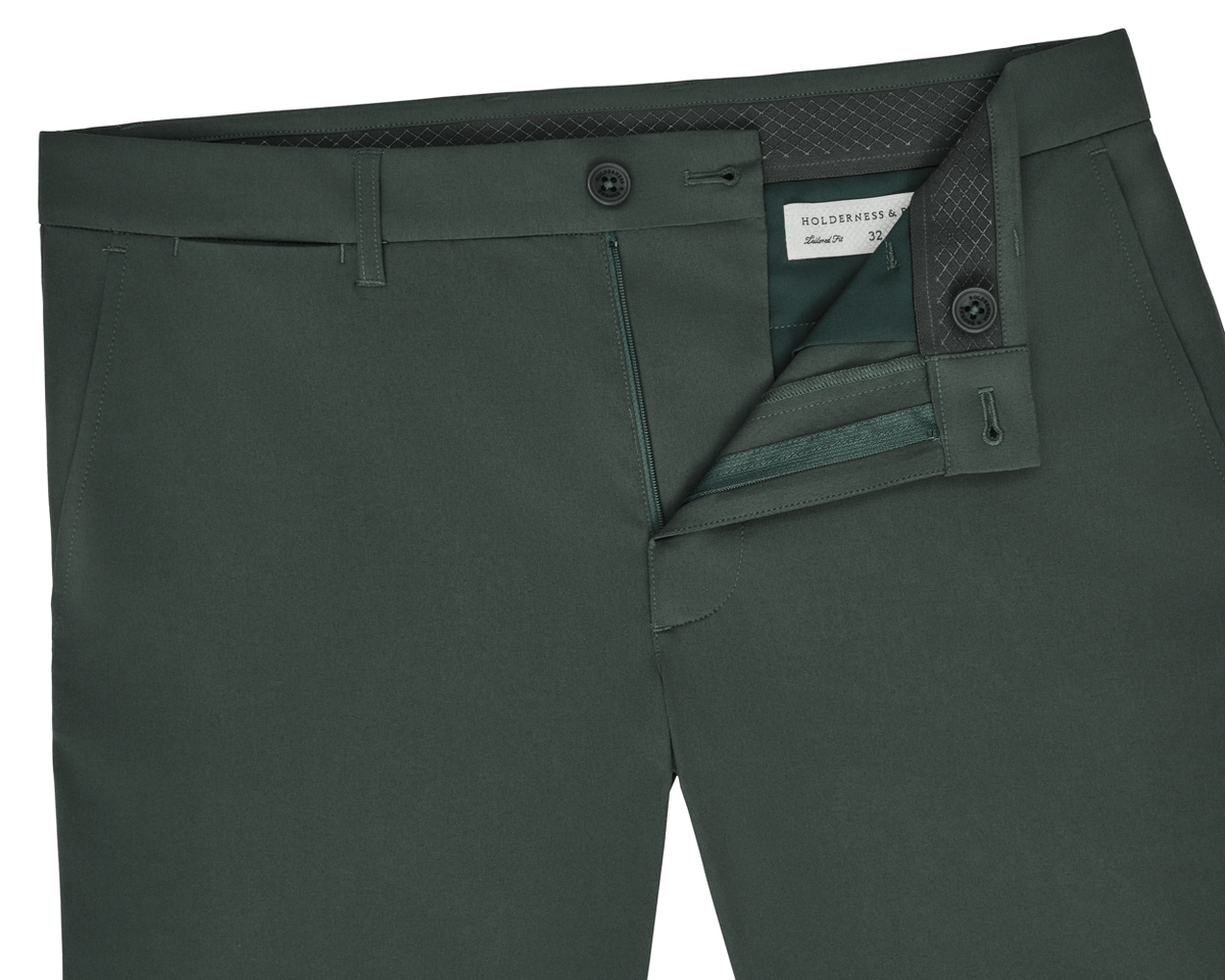 The Harwood Short: Ivy, showcasing front view with belt loops, button closure, zip fly, slash pockets, and visible inside waistband with label.