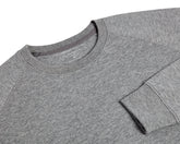 The Kennedy Crewneck: Heathered Gray, featuring a crew-neck design with visible collar, shoulder seams, and cuff, crafted from a soft cotton blend with terry interior.