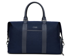 The Byers Duffel Bag: Navy Ballistic - Slate Blue Embroidery, featuring leather trim, dual handles, monogram CMB, and metal hardware for a shoulder strap.
