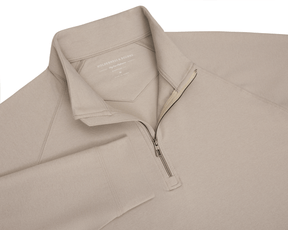 The Westland Quarter-Zip: Heathered Dune features a light tan pullover with a half-zip, soft peached fabric, and HOLDERNESS & BOURNE label visible.