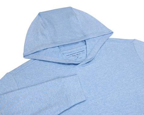 The Hamilton Hoodie: Heathered Horizon Blue & White, showcasing a light-blue, thinly striped design, hood, shoulder seams, and sleeve, crafted for comfort with 4-way stretch and UPF 50+ protection.