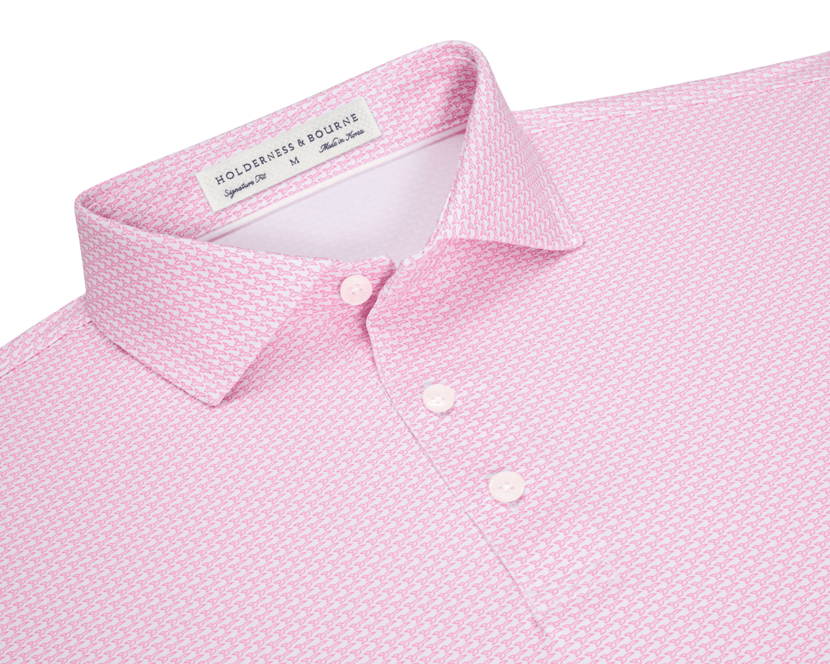 The Hanover Shirt: Belmont, a light pink polo with a geometric pattern, features a three-button placket, spread collar, and signature fit label inside.