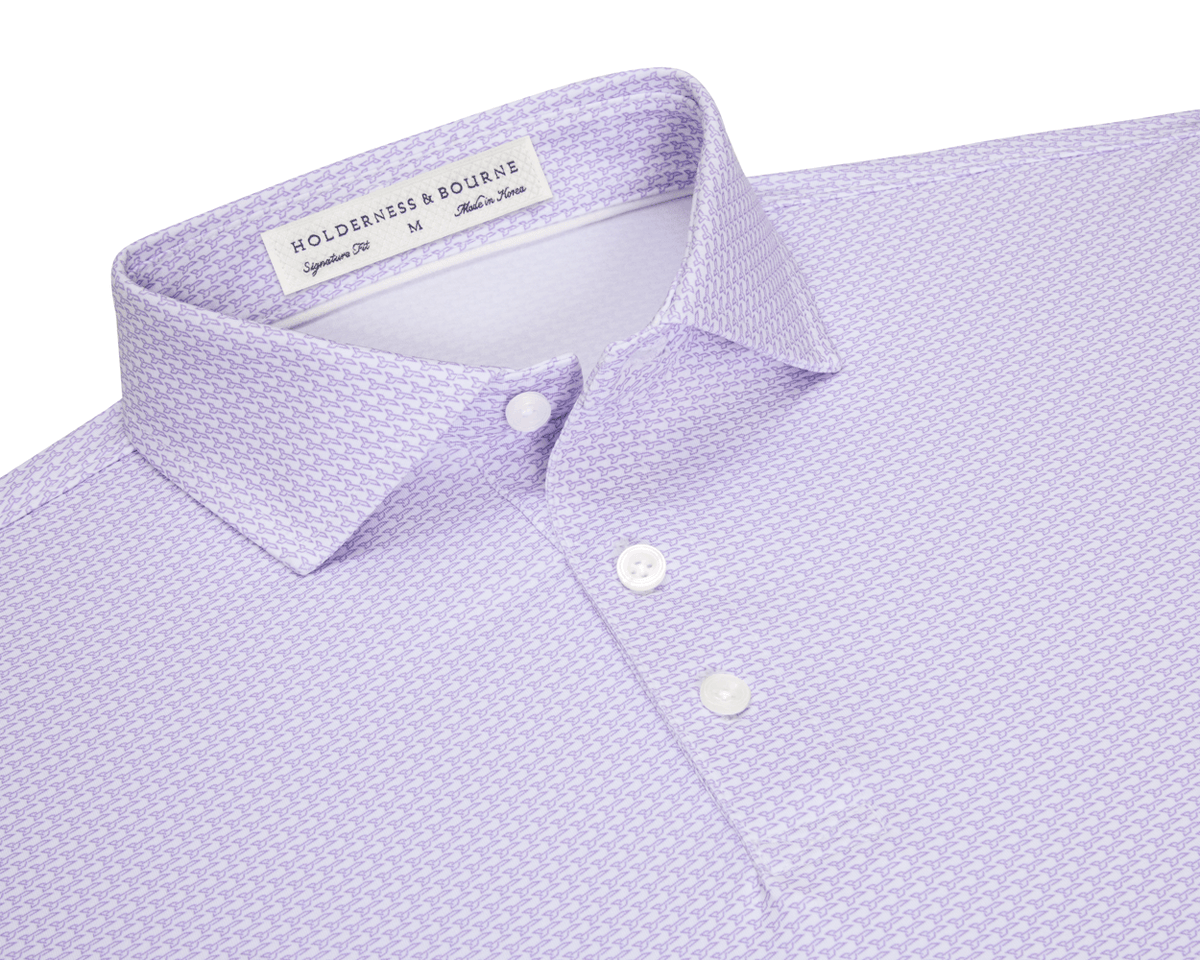 The Hanover Shirt: Tudor, a light lavender polo with a micro-pattern, features a soft spread collar, three white buttons, and a woven label.