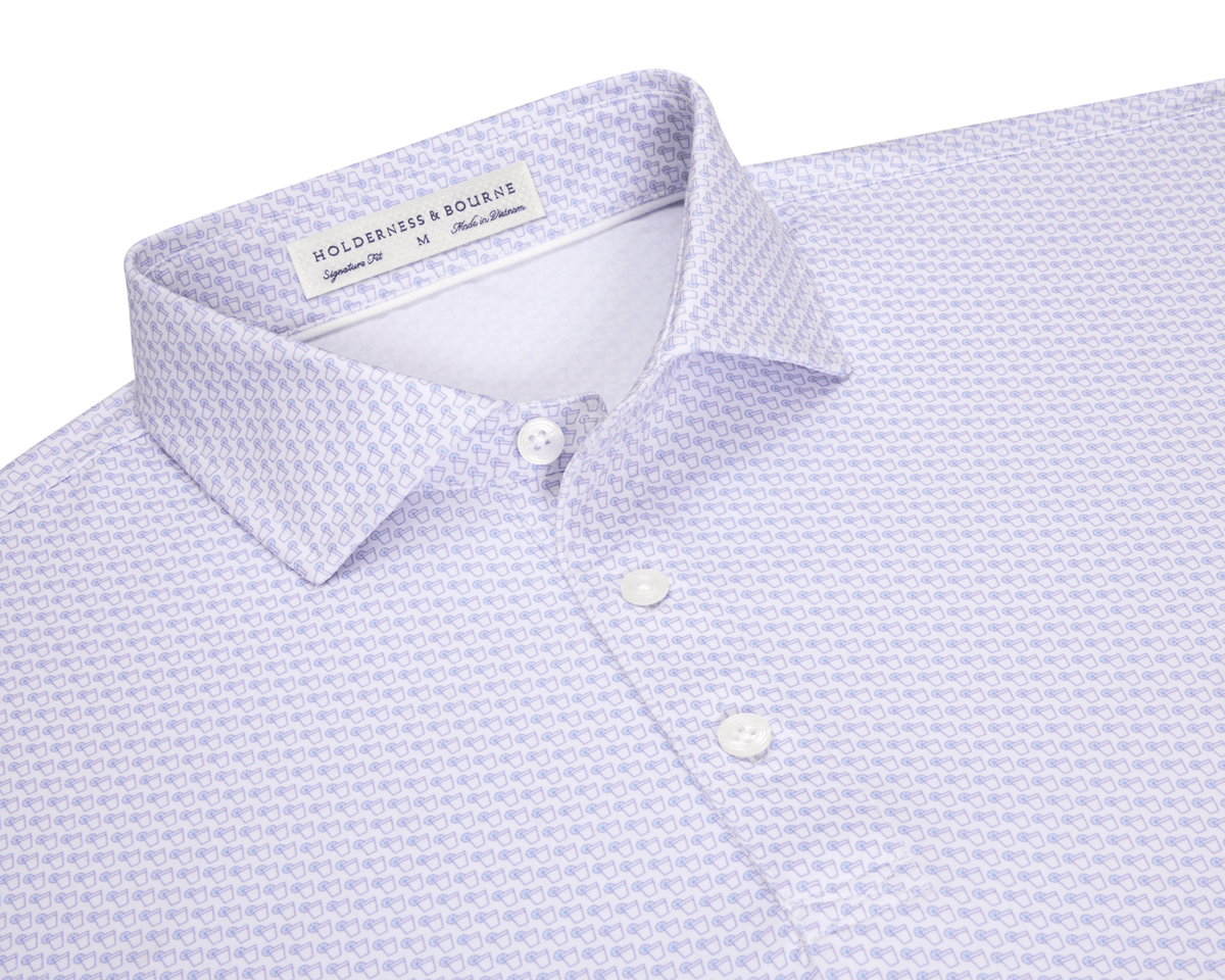 The Fulton Shirt: Vista Blue & Tudor, a men's button-up with a purple line-drawing pattern, classic spread collar, and white buttons, laid flat.
