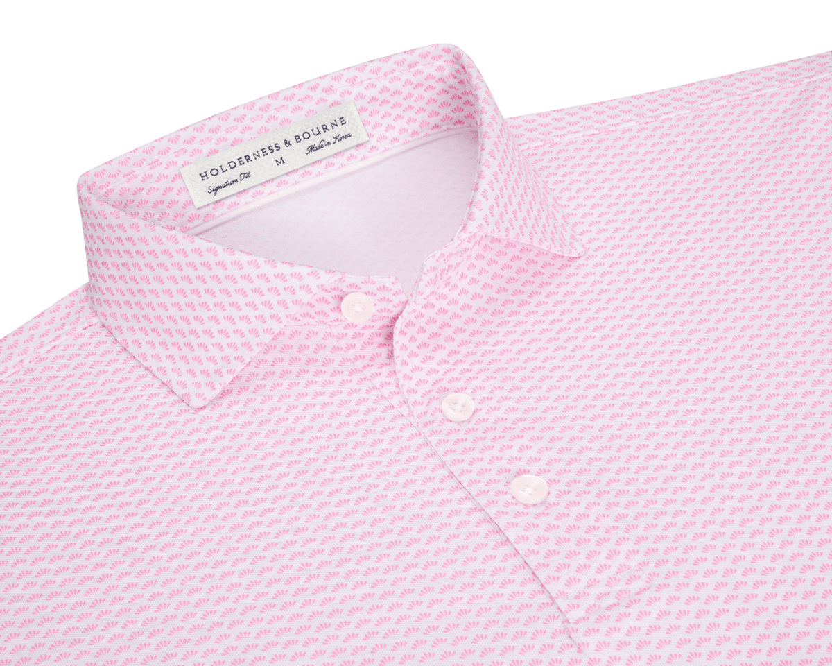 The Geiger Shirt: Belmont features a fan-patterned light-pink polo, three white buttons, and a structured collar, offering breathable, moisture-wicking comfort and UPF 30+ protection.