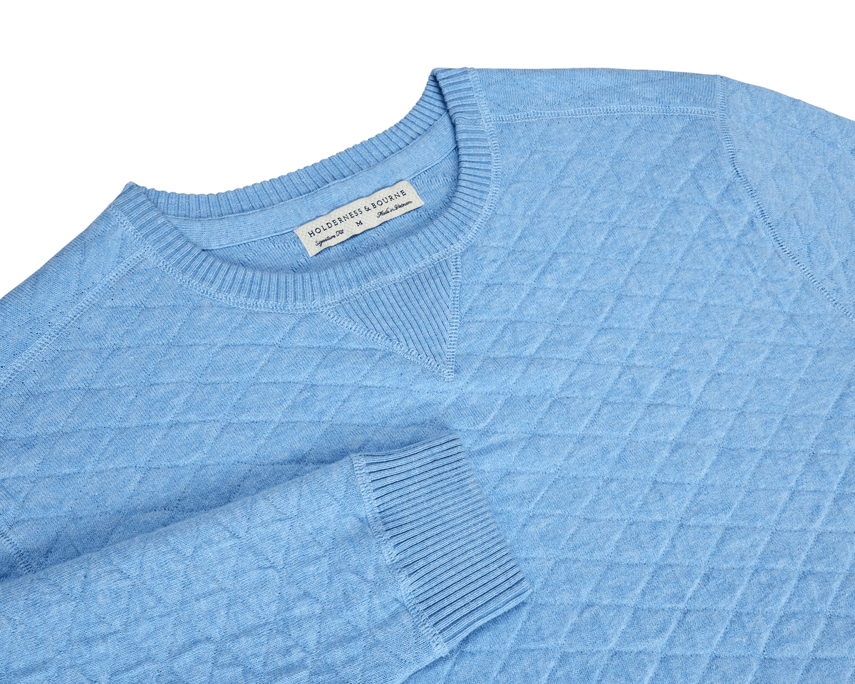The Ward Crewneck Sweater: Heathered Vista Blue features a quilted diamond-stitch texture and a Holderness & Bourne label, showcasing premium Egyptian cotton craftsmanship.
