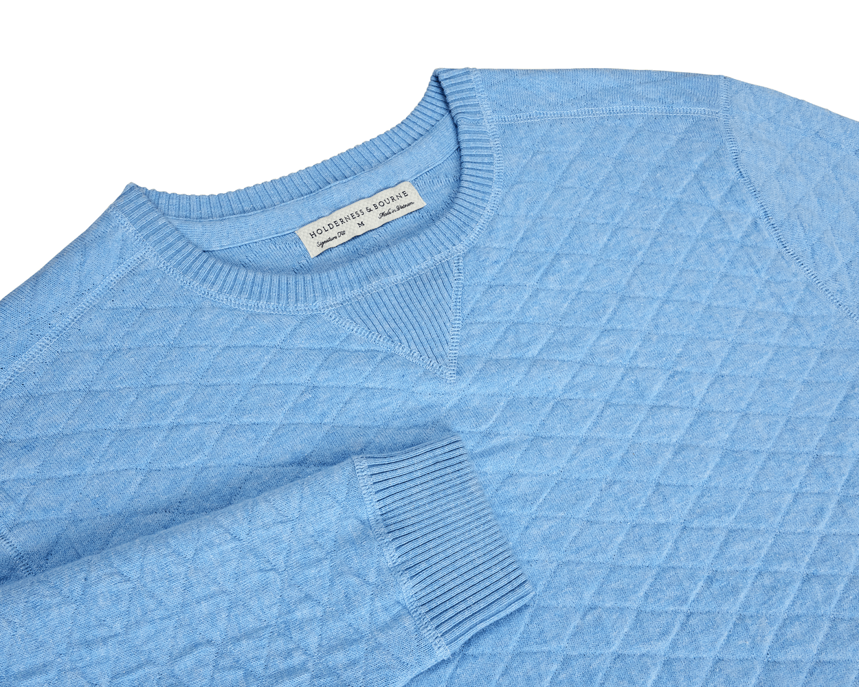 The Ward Crewneck Sweater: Heathered Vista Blue features a quilted diamond-stitch texture and a Holderness & Bourne label, showcasing premium Egyptian cotton craftsmanship.
