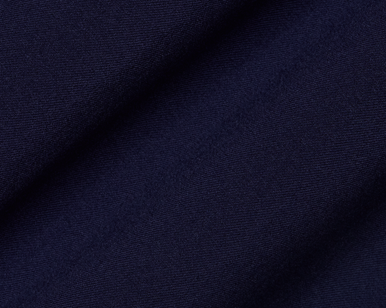 Close-up of The Anson Chino Pant: Navy, showcasing its fine woven texture and draping, highlighting the eco-friendly, wrinkle-resistant, and water-repellent fabric with four-way stretch.