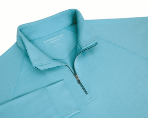 The Westland Quarter-Zip: Heathered Harbor features a light-blue pullover with a stand-up collar, half-length zipper, and raglan sleeves, showcasing Holderness & Bourne's slim fit.