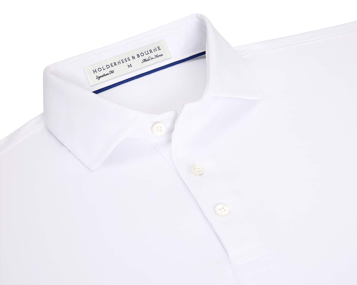 The Anderson Shirt: White, short-sleeved polo with structured spread collar, three-button placket, and performance fabric for stretch and moisture wicking. Size M, made in Korea.