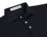 The Anderson Shirt: Black, featuring a dark-navy polo with a classic point collar, three white buttons, and a woven label, offering stretch and moisture-wicking comfort.