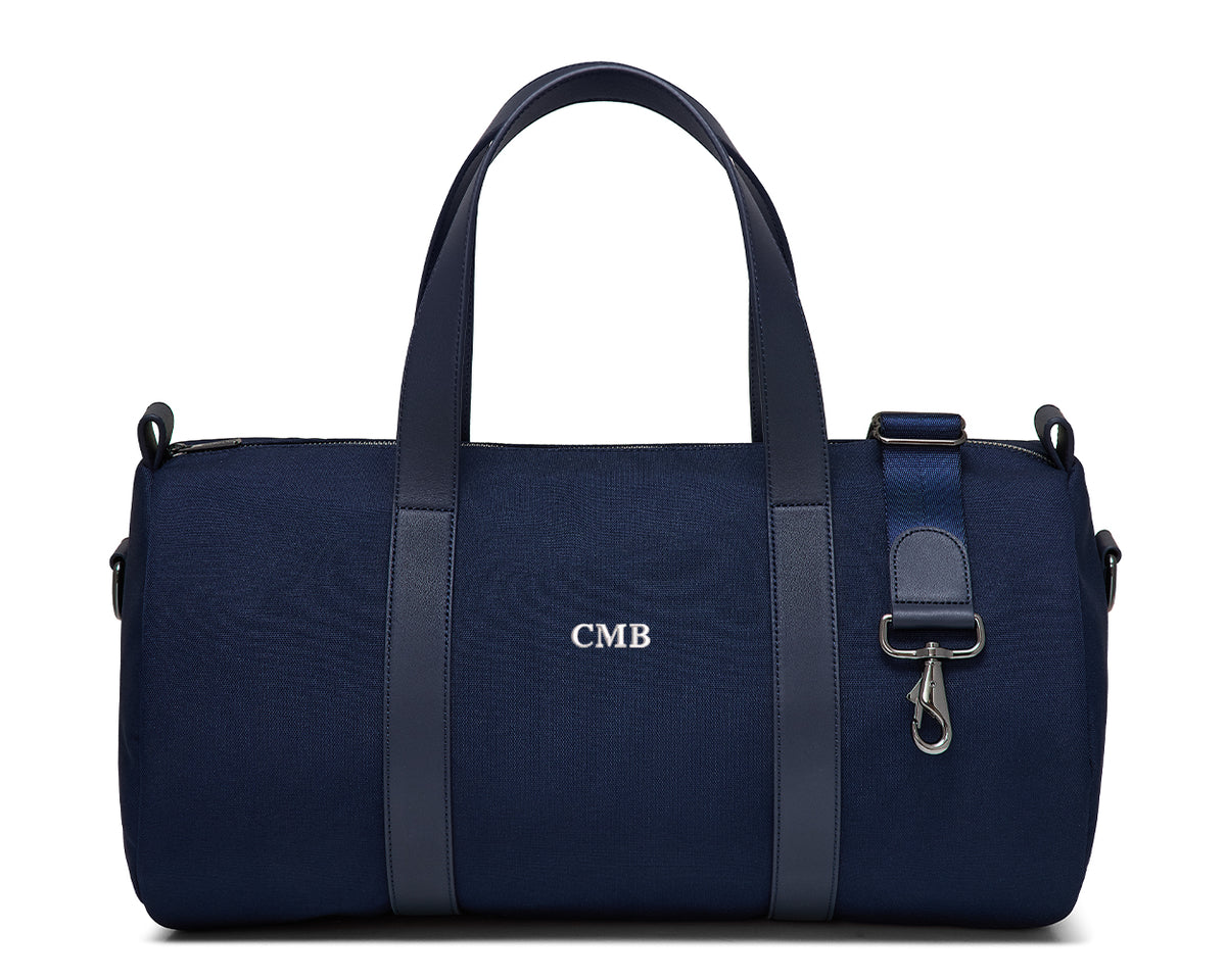 The Marston Banker Bag: Navy Ballistic - White Embroidery, featuring canvas fabric, leather trim, monogram CMB, top handles, detachable strap, and gunmetal hardware.