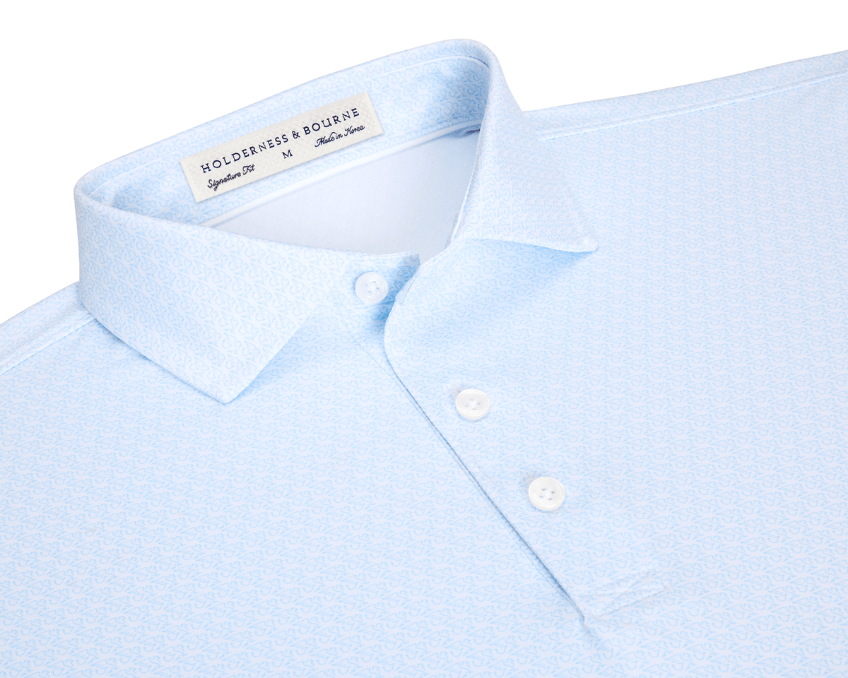 The Griffin Shirt: Vista Blue, featuring a light-blue geometric print, structured collar, and three-button placket, designed for comfort and versatility with performance fabric.