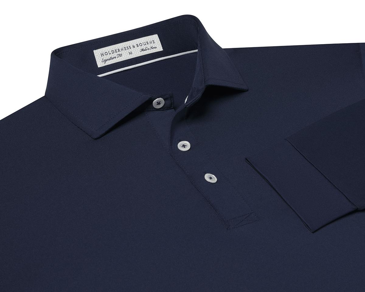 The Farrell Shirt: Navy, long-sleeve polo with a button placket, spread collar, and moisture-wicking jersey knit. Features include a label reading Holderness & Bourne, Signature Fit.