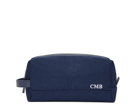 The Littler Dopp Kit: Navy Ballistic - White Embroidery, featuring a rectangular design with a top zipper, side handle, and personalized initials CMB.
