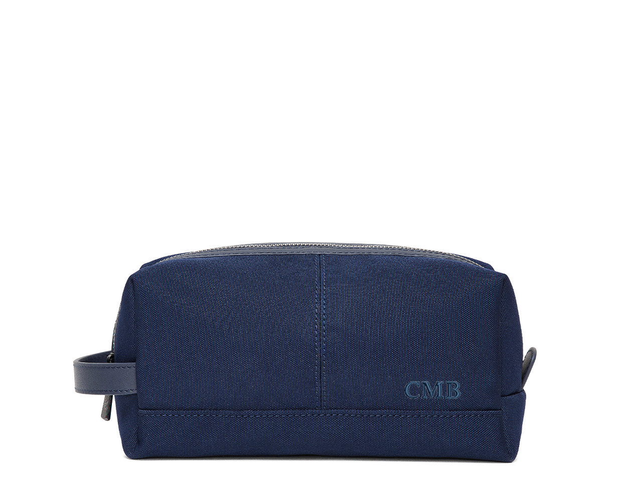 The Littler Dopp Kit: Navy Ballistic - Navy Embroidery, a sleek navy travel toiletry bag with a leather handle, top zipper, and debossed CMB initials.