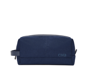 The Littler Dopp Kit: Navy Ballistic - Navy Embroidery, a sleek navy travel toiletry bag with a leather handle, top zipper, and debossed CMB initials.