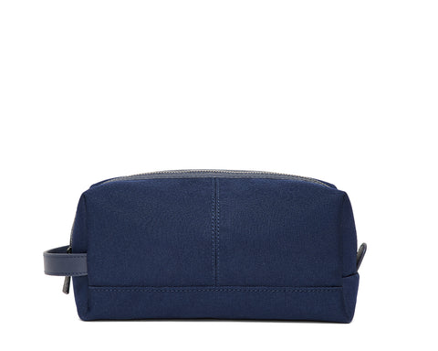 The Littler Dopp Kit: Navy Ballistic, a rectangular zippered toiletry bag with a fabric handle, features minimal stitching and a water-resistant interior pocket.