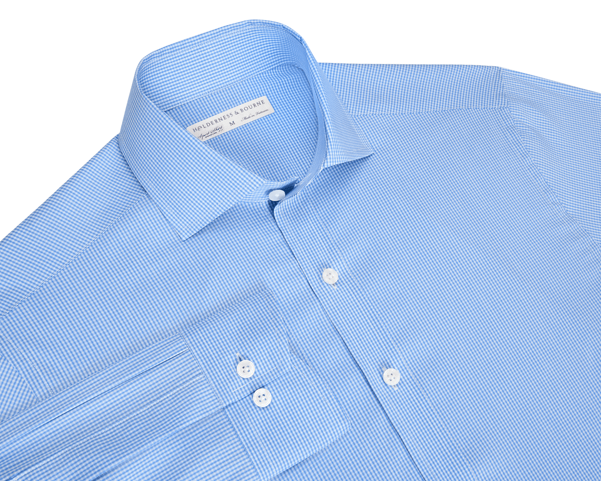 The McAllister Shirt: Horizon Blue, features a light blue micro-check pattern, spread collar, button-front, and white buttons, offering breathable, wrinkle-resistant comfort.