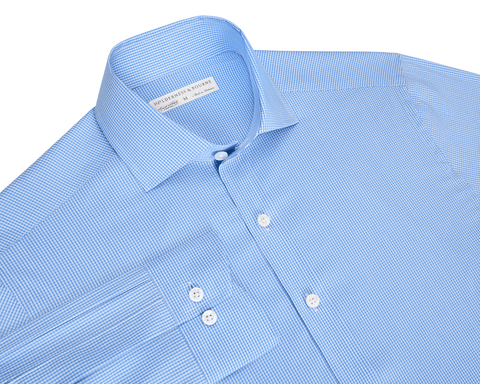 The McAllister Shirt: Horizon Blue, features a light blue micro-check pattern, spread collar, button-front, and white buttons, offering breathable, wrinkle-resistant comfort.