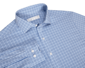 The Wright Shirt: Vista Blue, a men’s long-sleeve dress shirt with a blue windowpane pattern, spread collar, and white buttons, offers comfort and wrinkle resistance.