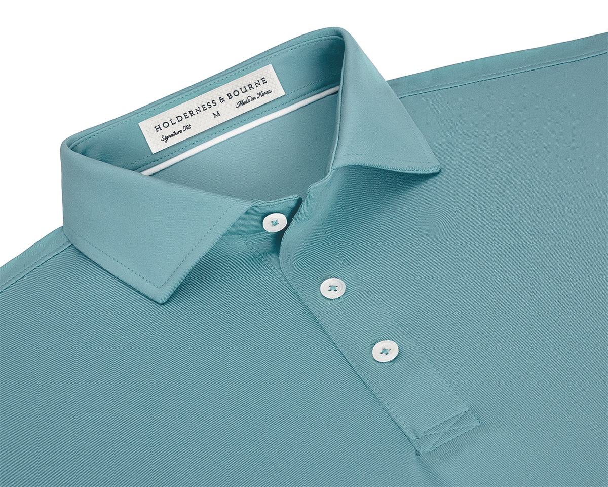 The Anderson Shirt: Harbor, featuring a structured spread collar, three-button placket, and jersey knit fabric for stretch and moisture wicking, laid flat.
