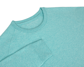 The Kennedy Crewneck: Heathered Harbor, featuring a visible raglan shoulder seam and cuffed sleeve, showcases a plush terry interior for comfort and year-round style.
