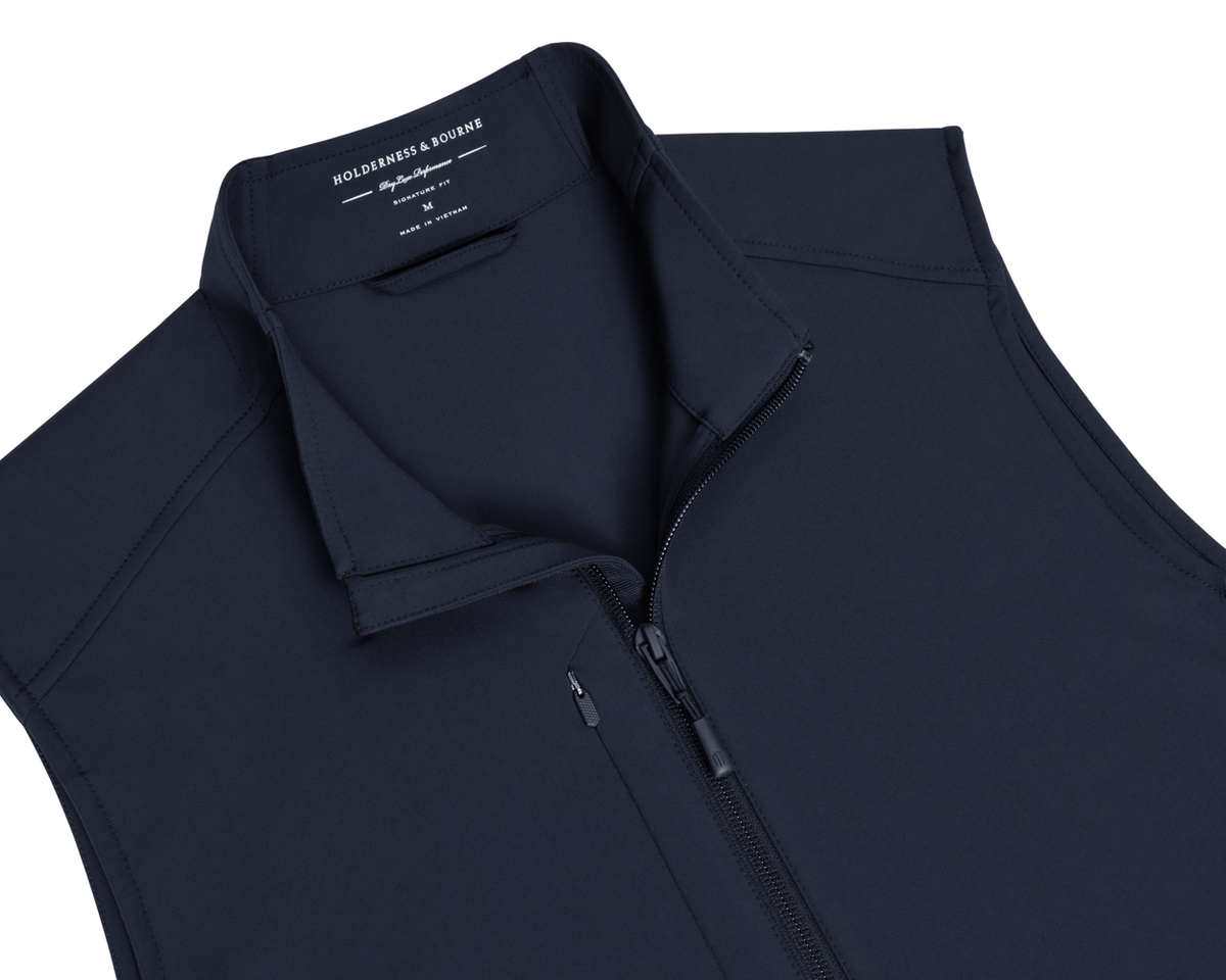 The Boyd Vest: Navy, a sleeveless, zip-up performance vest with stand collar, featuring Holderness & Bourne branding, designed for wind and water resistance with four-way stretch.
