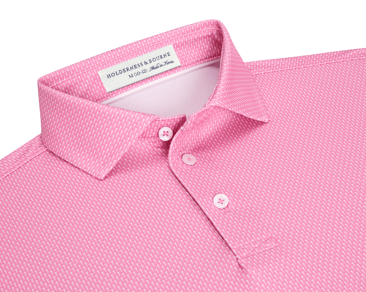 The Hicks Boys Shirt: Belmont, a pink polo with white geometric pattern, features a three-button placket, structured collar, and Holderness & Bourne label.