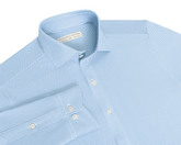 The Goodrich Shirt: Horizon Blue, light-blue button-up with a subtle woven pattern, point collar, white buttons, and breathable Swing Knit® fabric for versatile wear.