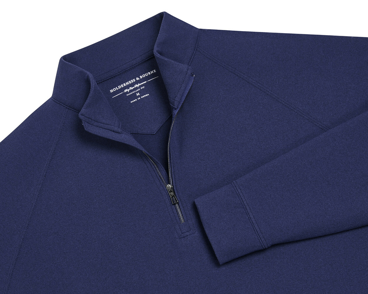 The Westland Quarter-Zip: Navy, features a dark-blue, long-sleeve design with gunmetal chrome trim, offering moisture-wicking performance and a soft, peached synthetic blend.