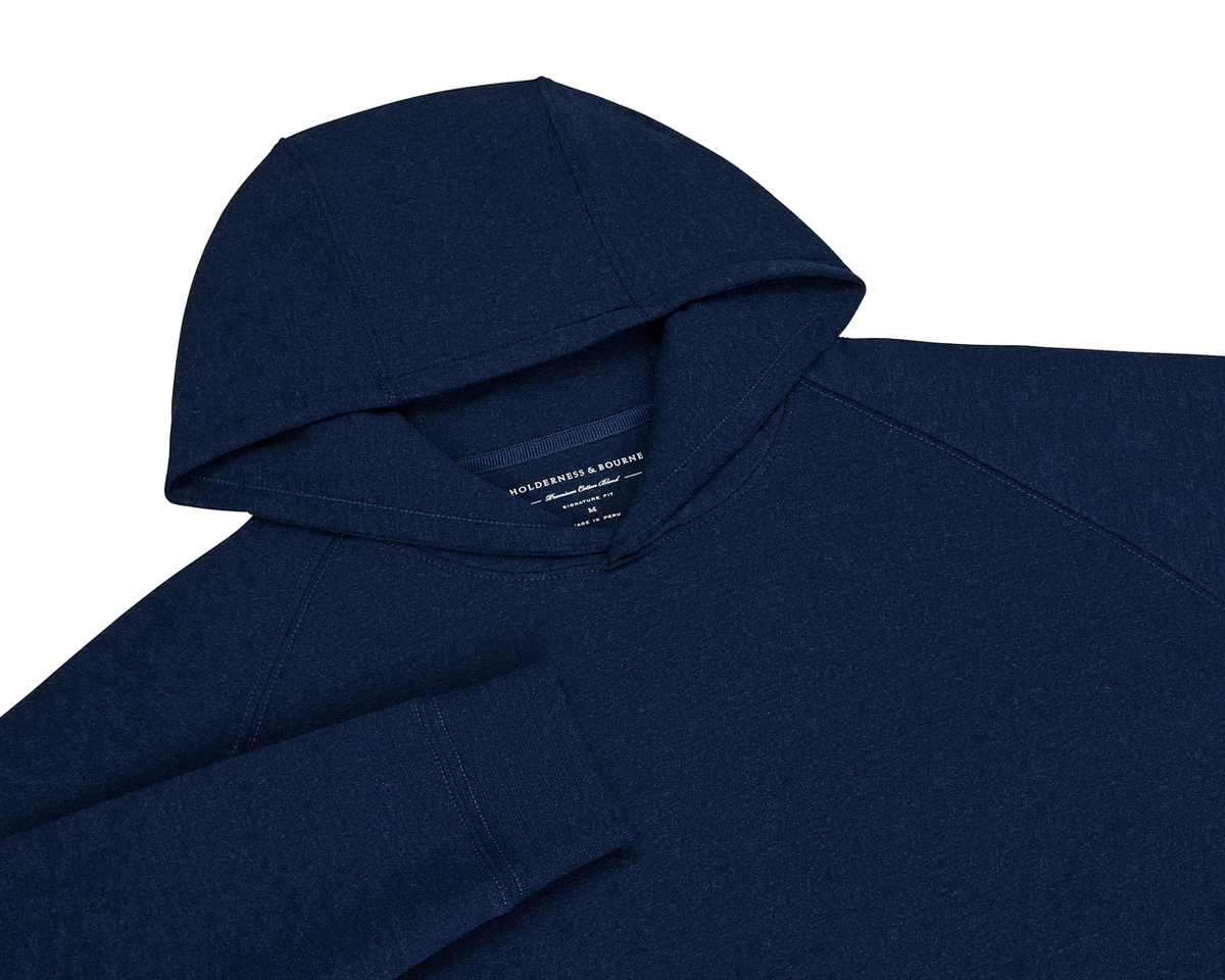 The Lawson Hoodie: Heathered Atlantic, a dark navy pullover with raglan sleeves and cuff, features an ultra-soft fabric and minimalistic design.