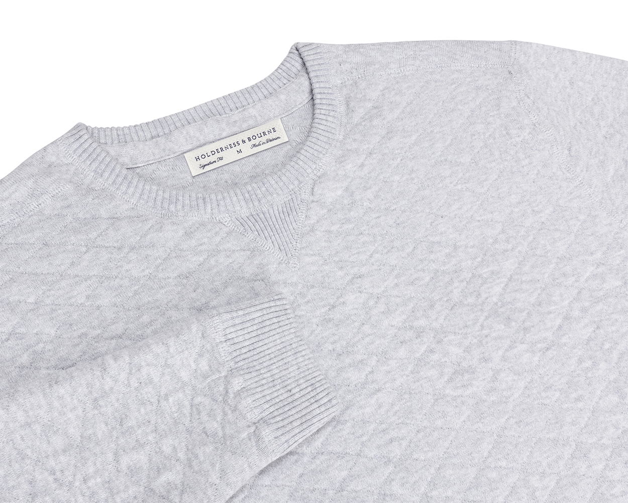 The Ward Crewneck Sweater: Heathered Gray features a textured knit pattern, ribbed details, V-stitch accent, and a Holderness & Bourne label inside the collar.