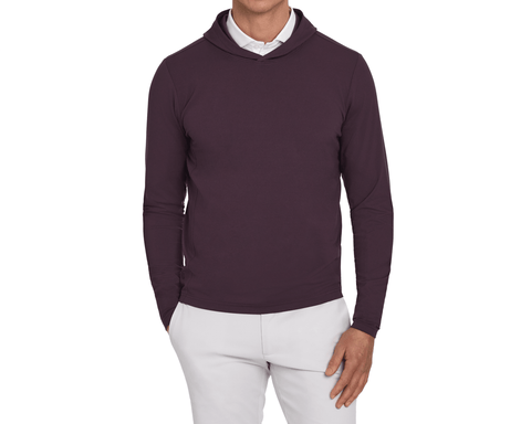 Model wearing The Jackson Hoodie: Vineyard, showing the hood, long sleeves, and plain front, with a white collar and light gray pants.