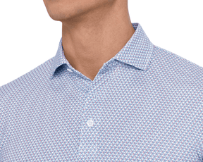 Close-up of a model wearing The Justice Shirt: Napa & Pacific Blue, showing the spread collar, white button, and blue and red print at the neckline.