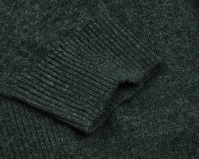 The Logan Hoodie Sweater: Heathered Ivy, showcasing a close-up of the ribbed sleeve cuff and textured knit fabric in a luxurious Merino wool and cashmere blend.