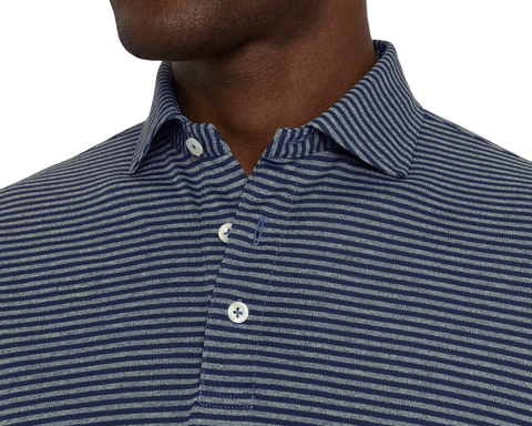 Close-up of a model wearing The Maxwell Shirt: Navy & Heathered Pacific Blue, showing the spread collar, button placket, and narrow navy and gray-blue stripes.