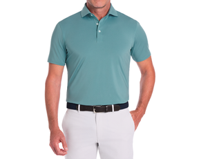 The Anderson Shirt: Harbor, a short-sleeve polo, showcases a structured collar and jersey knit fabric, offering stretch and moisture-wicking comfort, tucked into light pants with a dark belt.