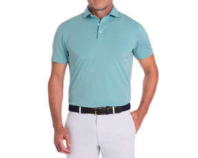 Man wearing The Holland Shirt: Heathered Harbor, a sophisticated polo with subtle stripes, tucked into light trousers, featuring a structured collar and navy woven belt.