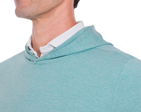 The Stowe Hoodie: Heathered Harbor, shown layered with a white shirt, features a soft, lightweight fabric, set-in sleeves, and an athletic drop-tail hem.