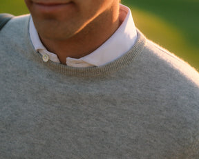 Person wearing The Buckley Crewneck Sweater: Heathered Gray, showcasing its classic design with a visible crew neckline and durable doubled cuffs.
