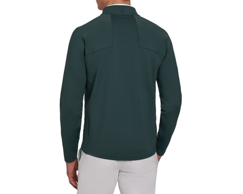 Back view of a male model wearing The Rodgers Quarter-Zip: Cypress, showing the paneled yoke, raglan sleeves, curved hem, and light gray pants.