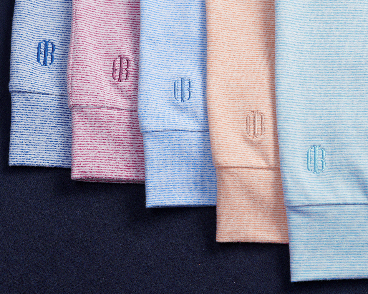 The Hamilton Hoodie: Heathered Harbor & White with fine stripes, folded neatly, showcasing the CB monogram on cuffs, highlighting comfort and versatility.