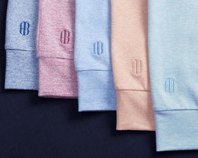 The Hamilton Hoodie: Heathered Harbor & White with fine stripes, folded neatly, showcasing the CB monogram on cuffs, highlighting comfort and versatility.
