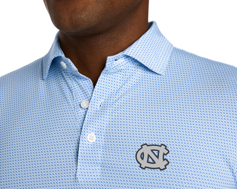 Close-up of University of North Carolina Norman Shirt: Vista Blue & Horizon Blue on a model, showing the open collar, white buttons, placket, and embroidered NC logo on the chest.