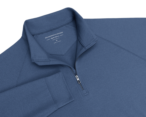 Close-up of The Westland Quarter-Zip: Heathered Pacific Blue showing the quarter-zip, raglan sleeve seam, collar, and Holderness & Bourne neck label.