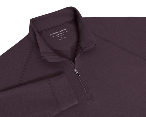 Flat-lay of The Westland Quarter-Zip: Heathered Vineyard showing its raglan sleeves, gunmetal half-zipper, stand collar, and woven brand label inside the neck.